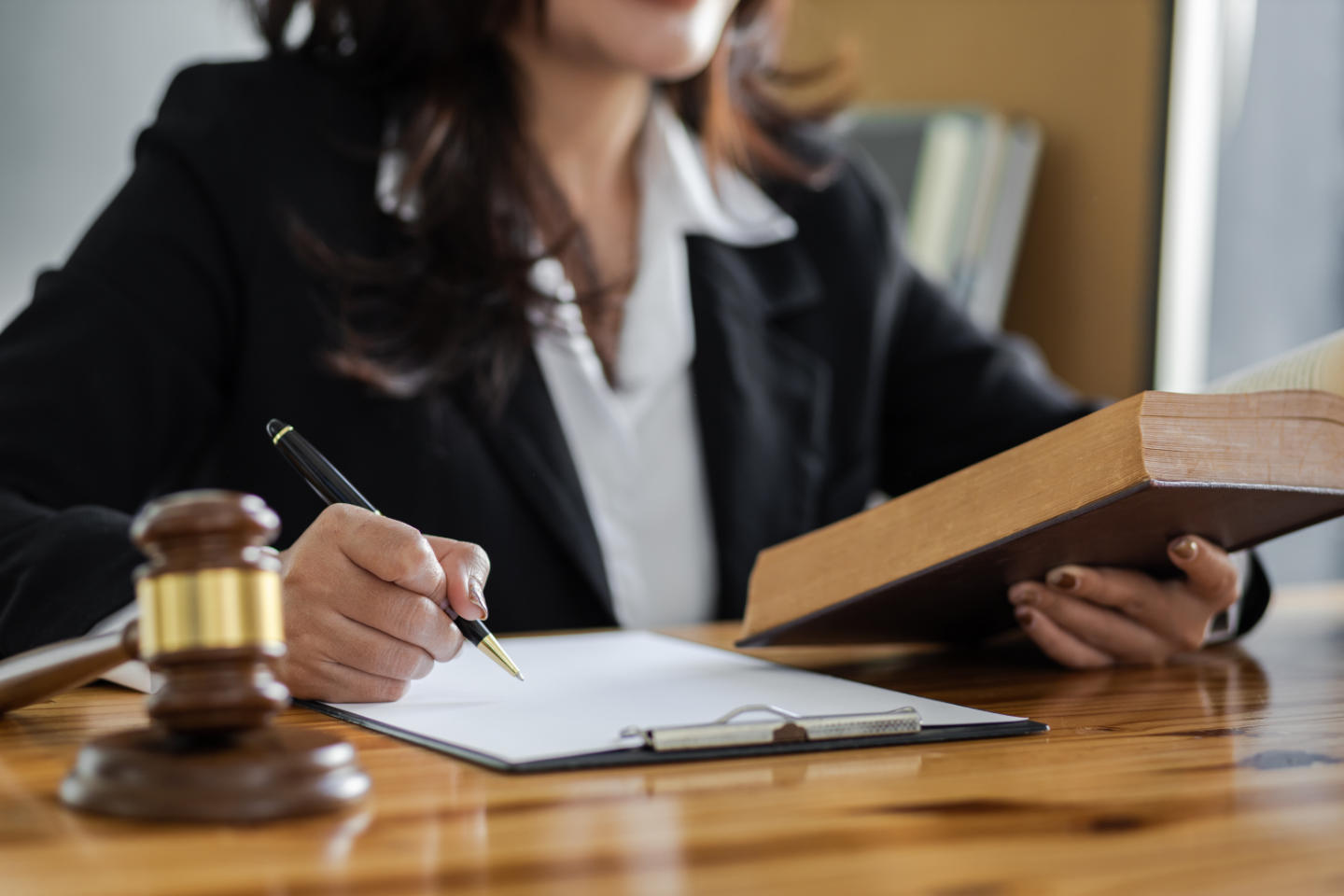 Female lawyer working in a law office reading a law book on the